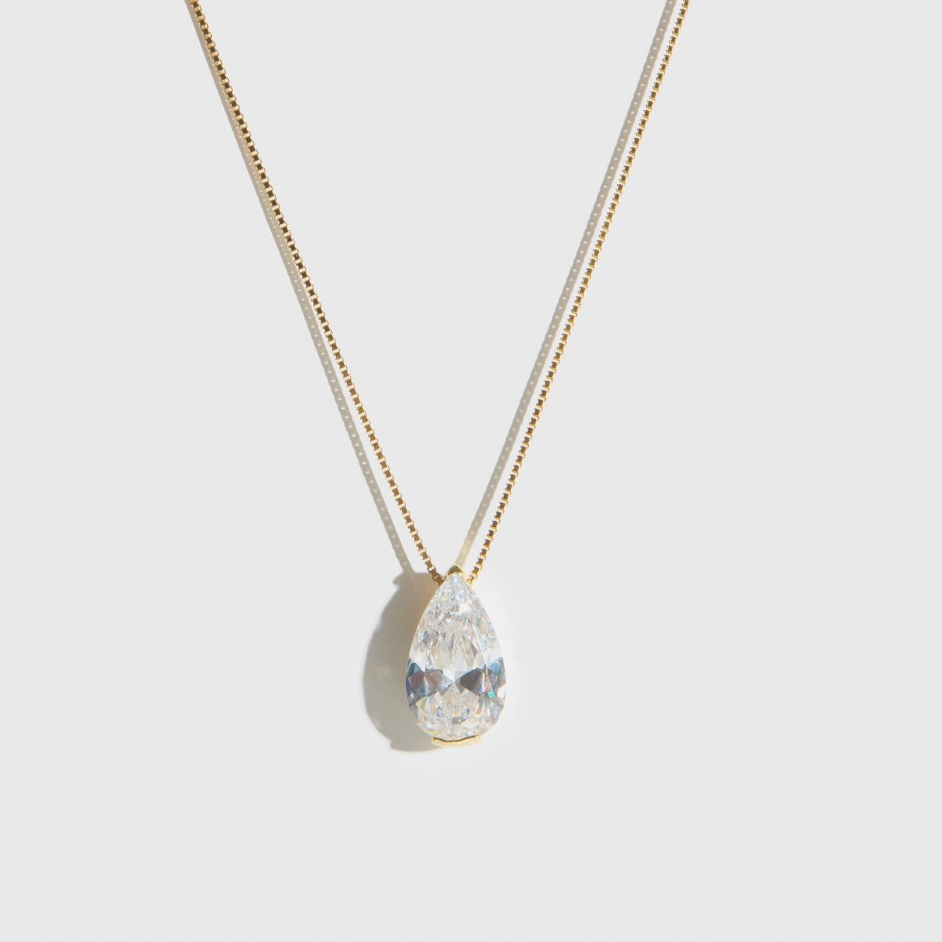 14k gold plated sterling silver 925 solitaire teardrop pendant necklace with a teardrop cubic zirconia, shown on a plain background.