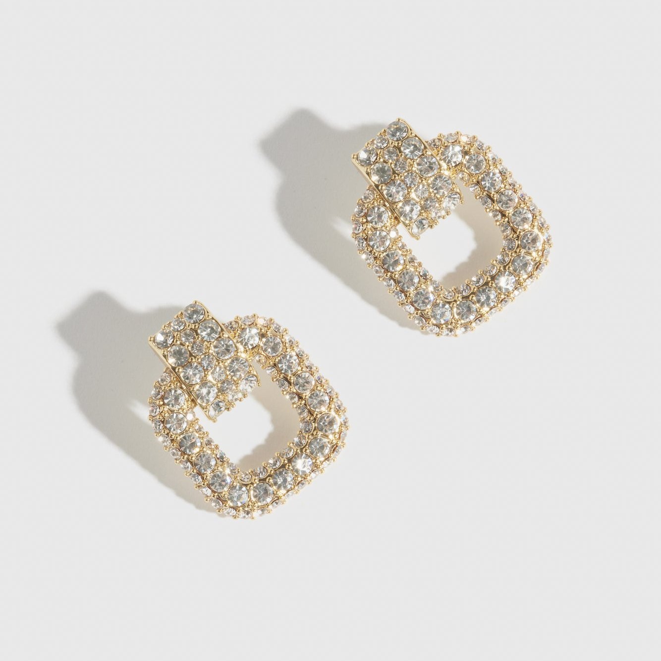 14k gold plated buckle pavé stud earrings with cubic zirconia, shown on a plain background.