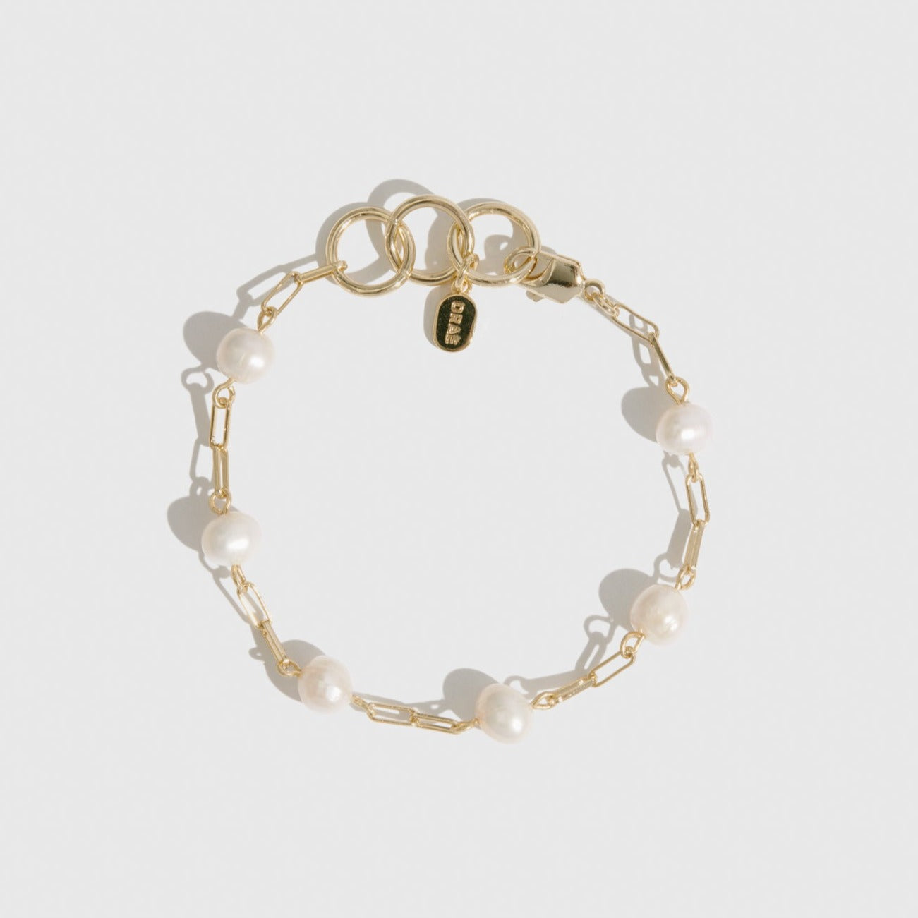 14k gold plated sterling silver 925 paper clips and pearls bracelet with freshwater pearls, shown on a plain background.