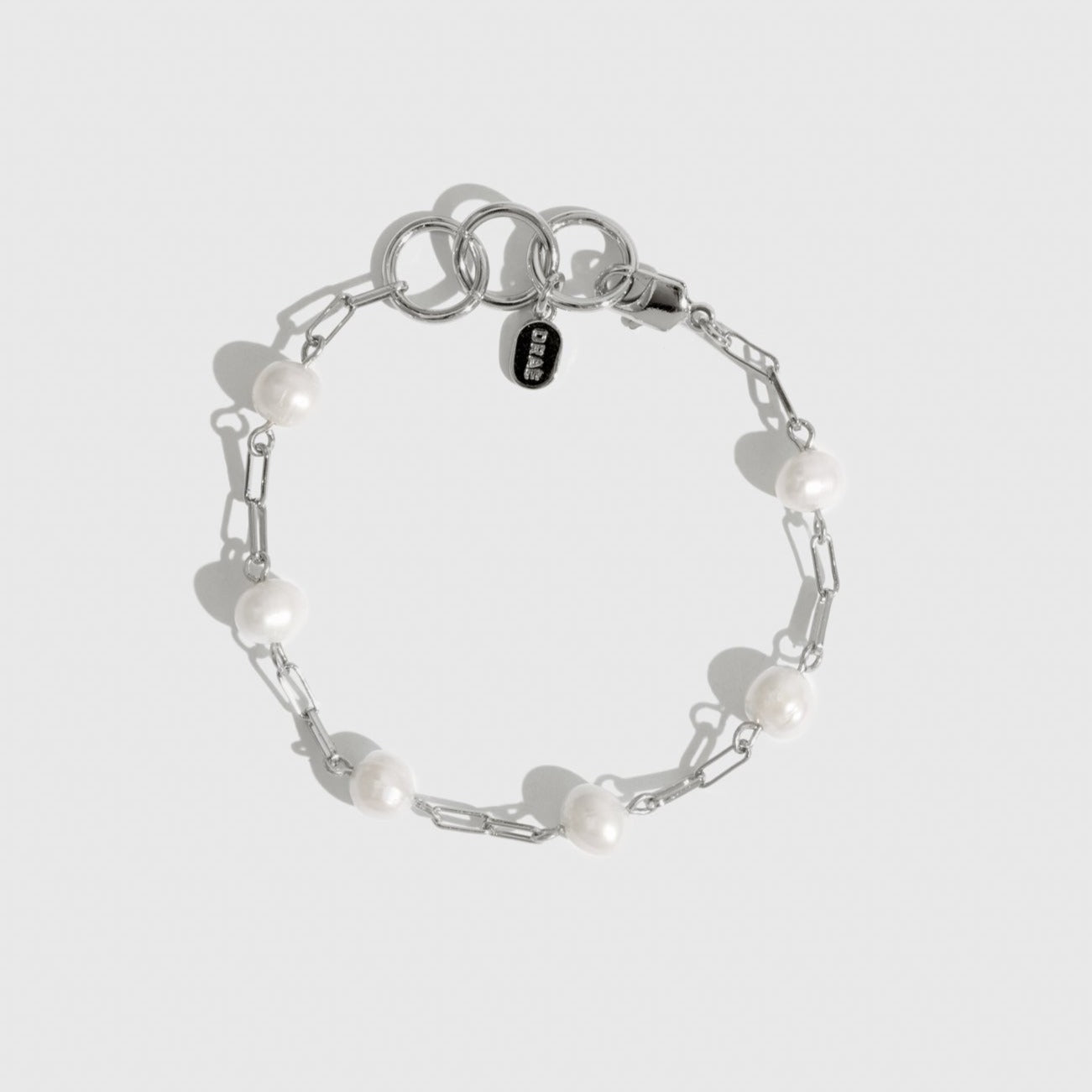 Sterling silver 925 paper clips and pearls bracelet with freshwater pearls, shown on a plain background.