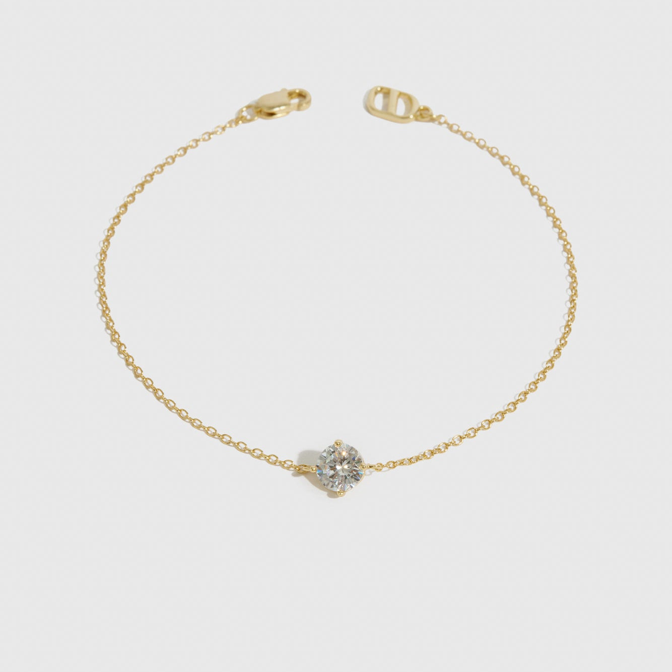 14k gold plated sterling silver 925 round-cut solitaire bracelet with a pure white cubic zirconia, shown on a plain background.