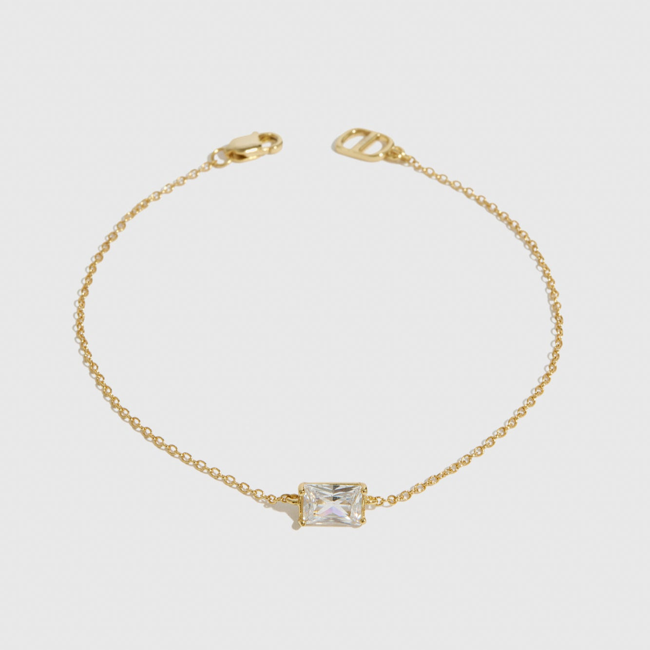 14k gold plated sterling silver 925 baguette-cut solitaire bracelet with a pure white cubic zirconia, shown on a plain background.