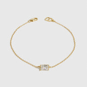 14k gold plated sterling silver 925 baguette-cut solitaire bracelet with a pure white cubic zirconia, shown on a plain background.