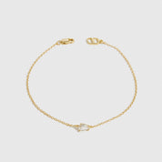 14k gold plated sterling silver 925 mini teardrop-cut solitaire bracelet with a pure white cubic zirconia, shown on a plain background.