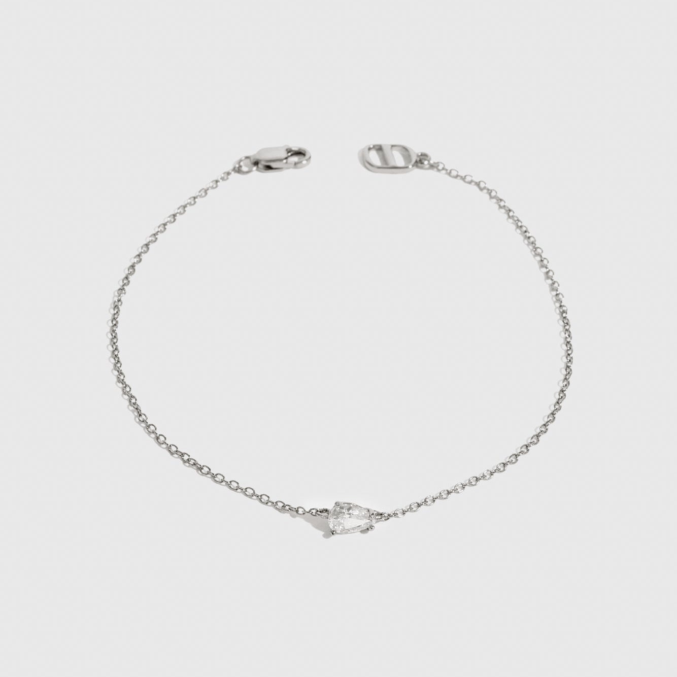 Sterling silver 925 mini teardrop-cut solitaire bracelet with a pure white cubic zirconia, shown on a plain background.