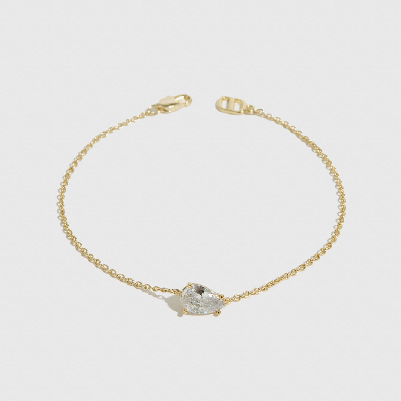 14k gold plated sterling silver 925 regular teardrop-cut solitaire bracelet with a pure white cubic zirconia, shown on a plain background.