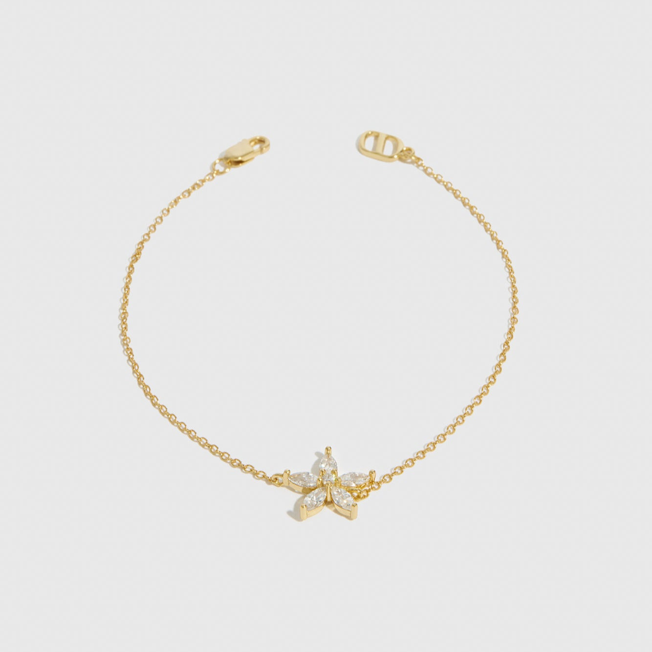 14k gold plated sterling silver 925 flower solitaire bracelet with a pure white cubic zirconia, shown on a plain background.