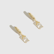 14k gold plated sterling silver 925 baguette-cut solitaire huggies with a pure white cubic zirconia, shown on a plain background.