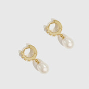 Gold hoop earrings with pearl drops on a white background