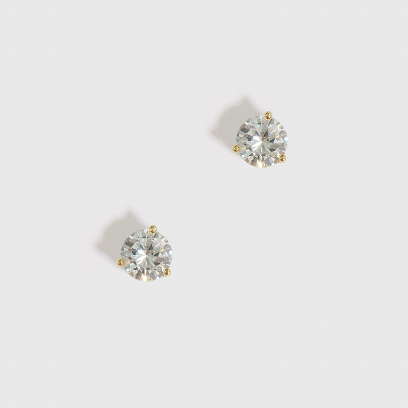 14k gold plated sterling silver 925 round-cut solitaire stud earrings with a pure white cubic zirconia, shown on a plain background.