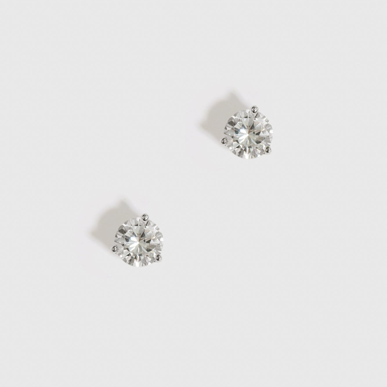 Sterling silver 925 round-cut solitaire stud earrings with a pure white cubic zirconia, shown on a plain background.