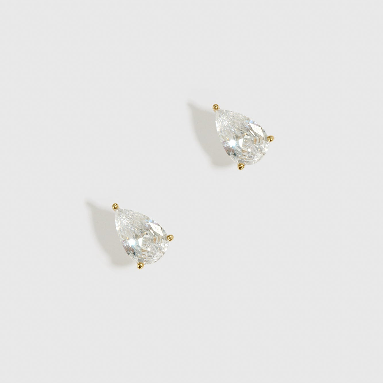 14k gold plated sterling silver 925 regular teardrop-cut solitaire stud earrings with a pure white cubic zirconia, shown on a plain background.