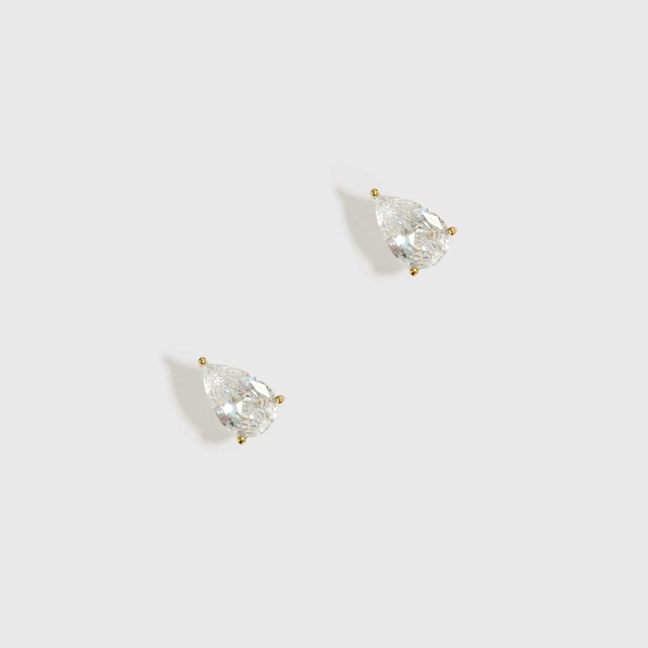 14k gold plated sterling silver 925 mini teardrop-cut solitaire stud earrings with a pure white cubic zirconia, shown on a plain background.