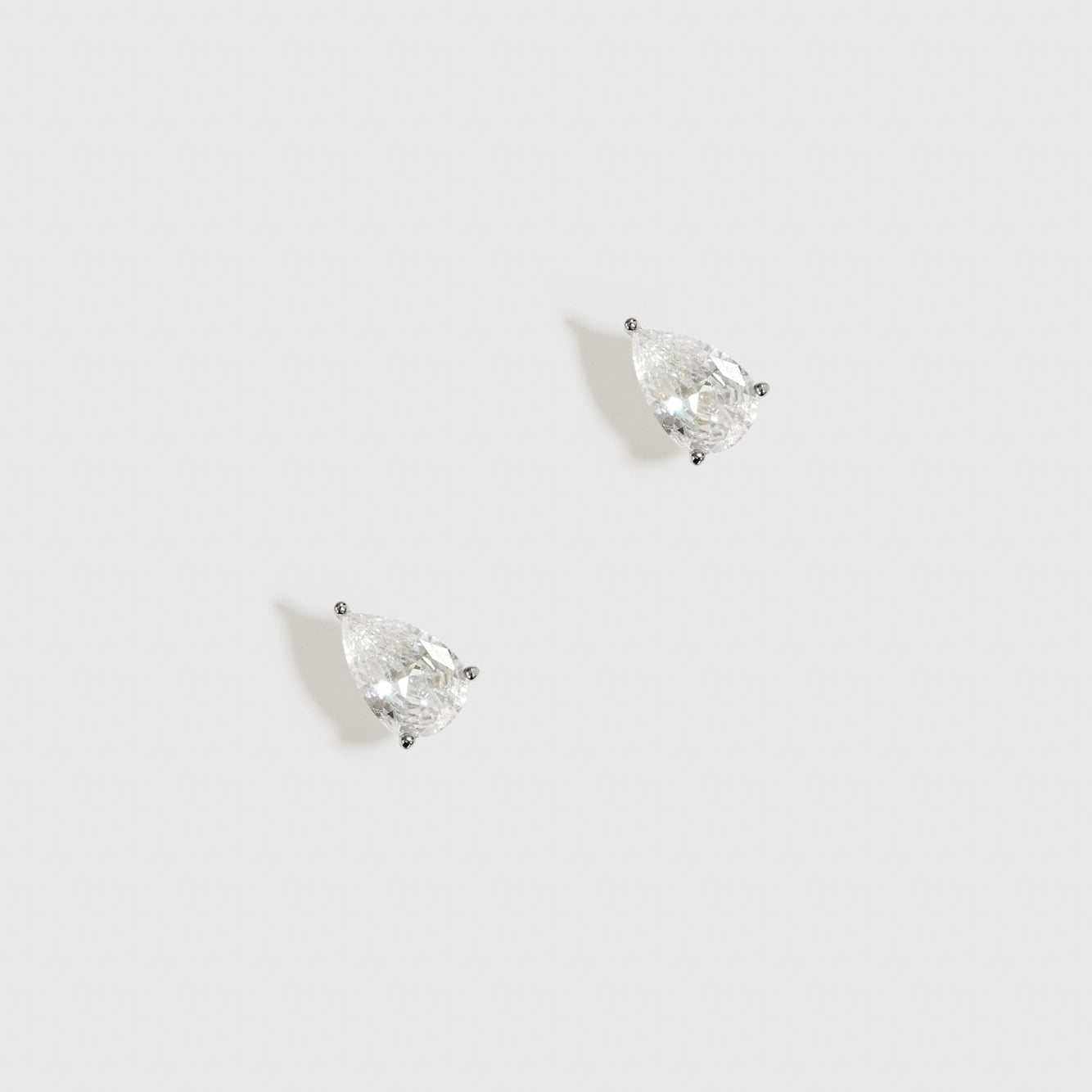 Sterling silver 925 mini teardrop-cut solitaire stud earrings with a pure white cubic zirconia, shown on a plain background.