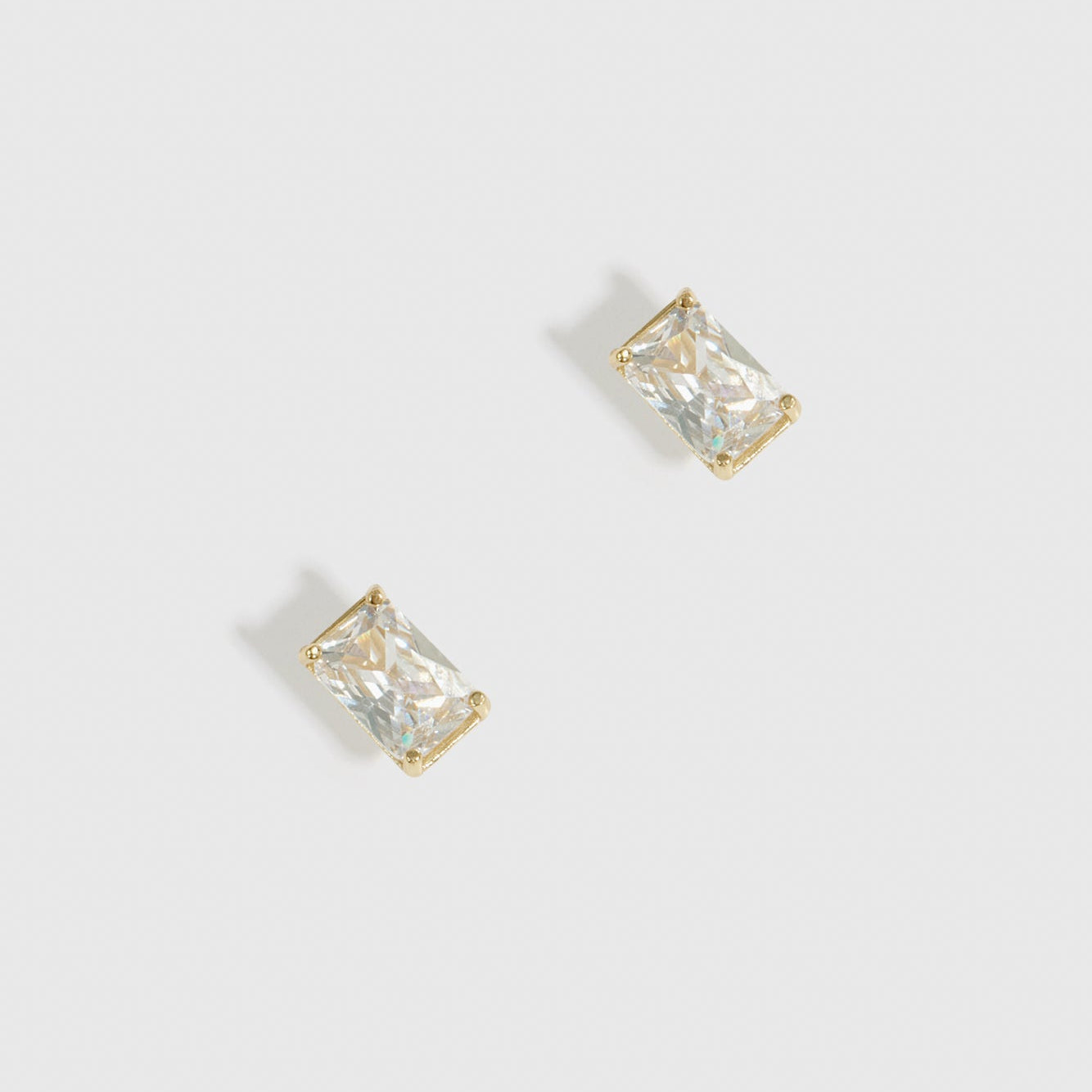 14k gold plated sterling silver 925 baguette-cut solitaire stud earrings with a pure white cubic zirconia, shown on a plain background.