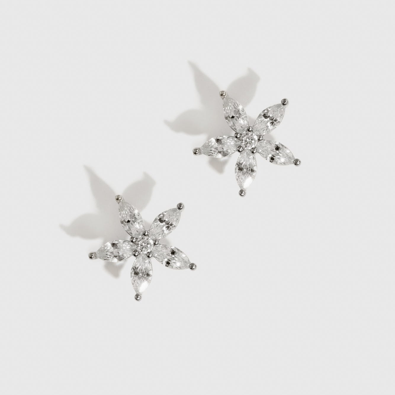 Sterling silver 925 flower solitaire stud earrings with a pure white cubic zirconia, shown on a plain background.