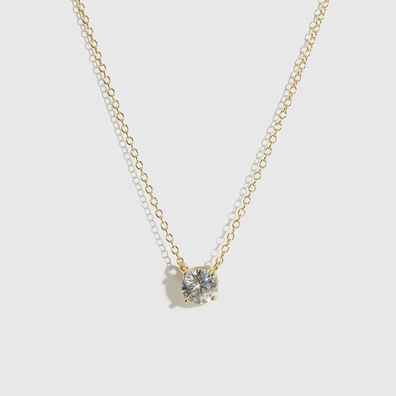 14k gold plated sterling silver 925 round-cut solitaire necklace with a pure white cubic zirconia, shown on a plain background.