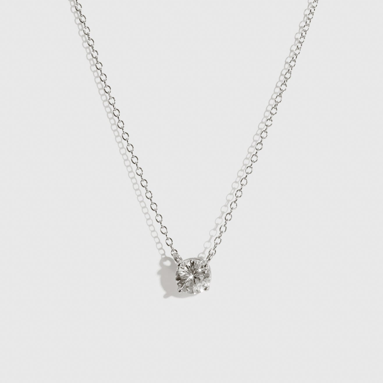 Sterling silver 925 round-cut solitaire necklace with a pure white cubic zirconia, shown on a plain background.