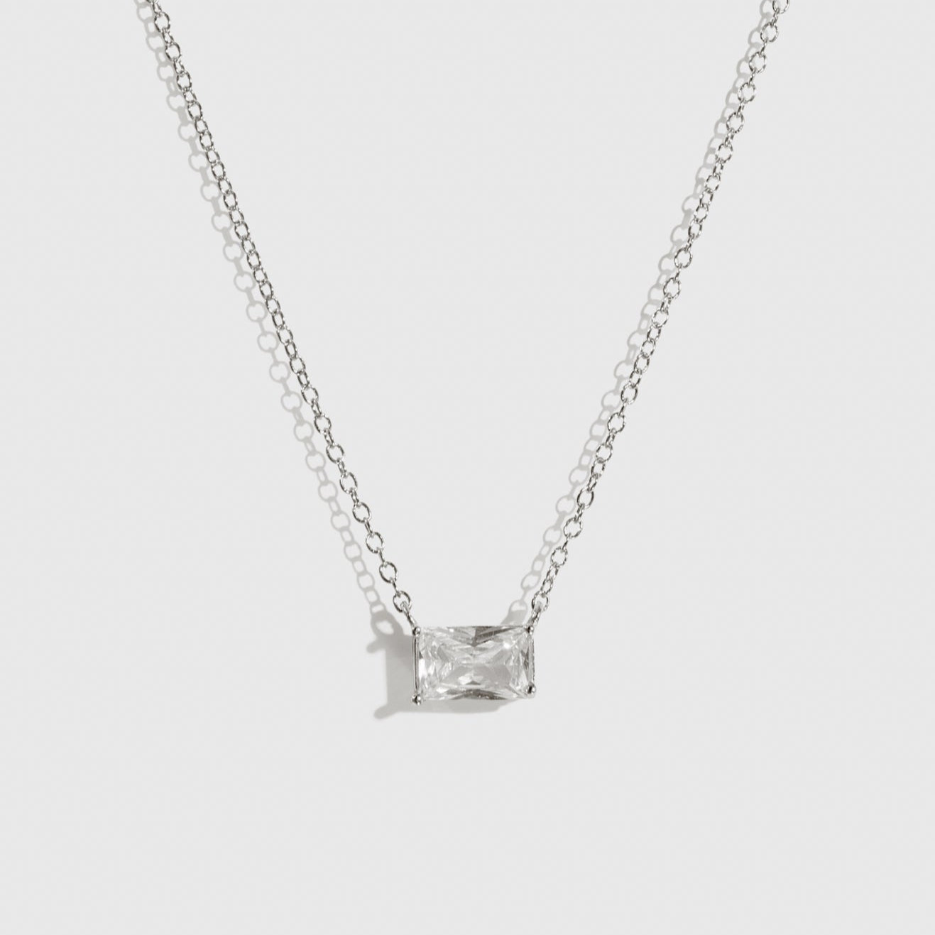 Sterling silver 925 baguette-cut solitaire necklace with a pure white cubic zirconia, shown on a plain background.
