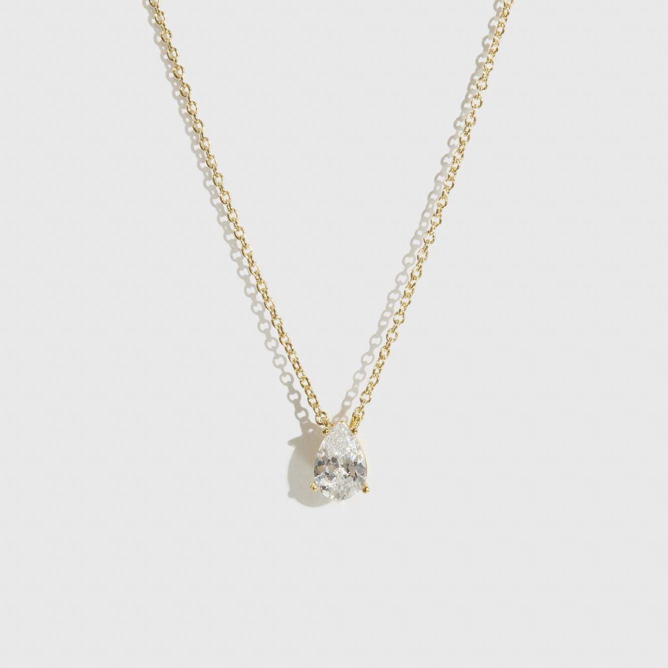 14k gold plated sterling silver 925 regular teardrop-cut solitaire necklace with a pure white cubic zirconia, shown on a plain background.