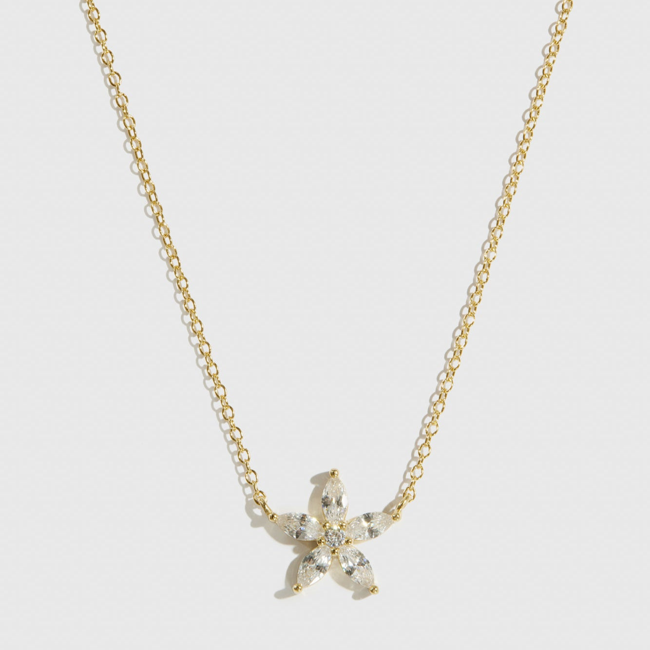 14k gold plated sterling silver 925 flower solitaire necklace with a pure white cubic zirconia, shown on a plain background.