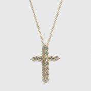 Gold cross necklace with clear stones on a white background