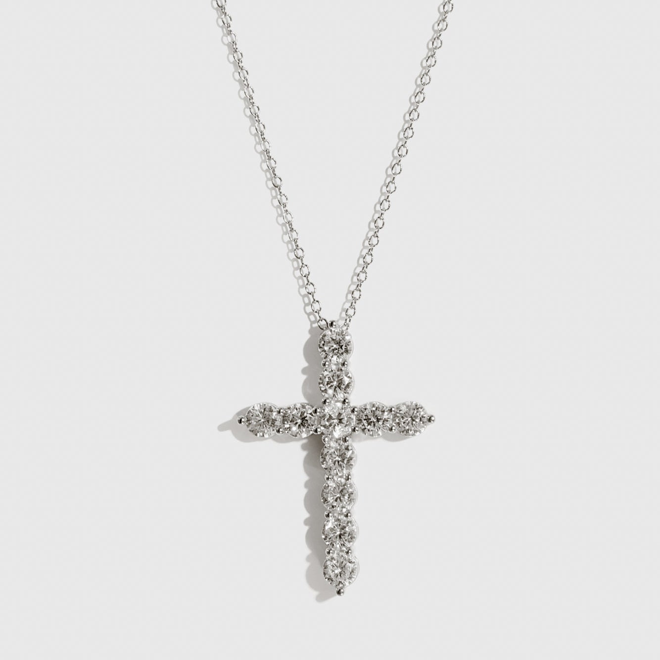 Sterling silver 925 regular dainty pavé cross necklace with cubic zirconia, shown on a plain background.