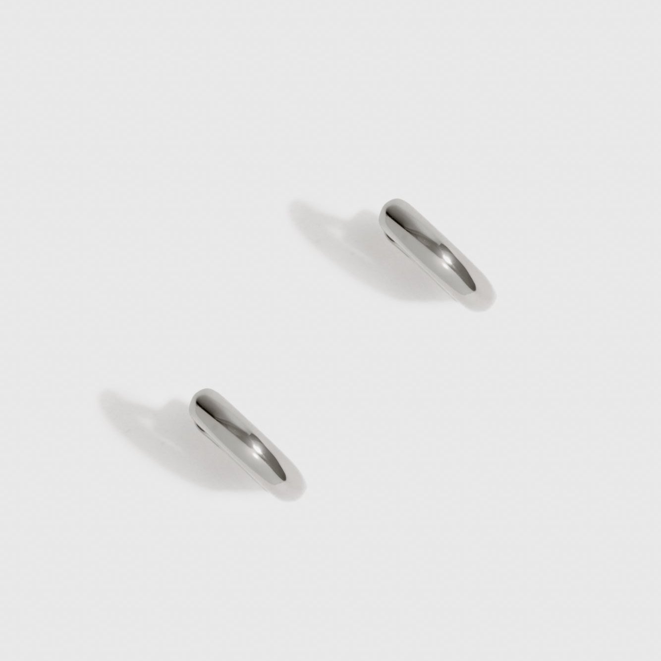 Sterling silver 925 mini plain huggie earrings, shown on a plain background.