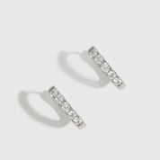 Sterling silver 925 classic pavé huggie earrings with pavé cubic zirconia, shown on a plain background.