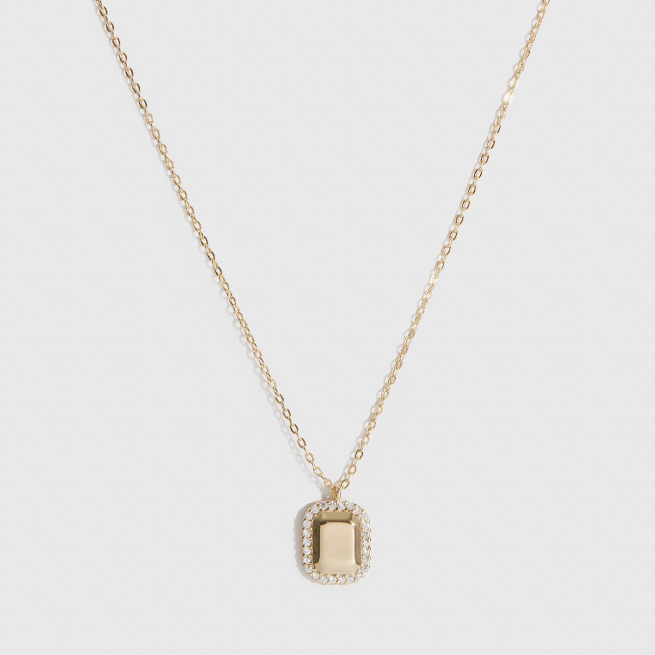 14k gold plated sterling silver 925 dainty dog tag pendant necklace with cubic zirconia, shown on a plain background.