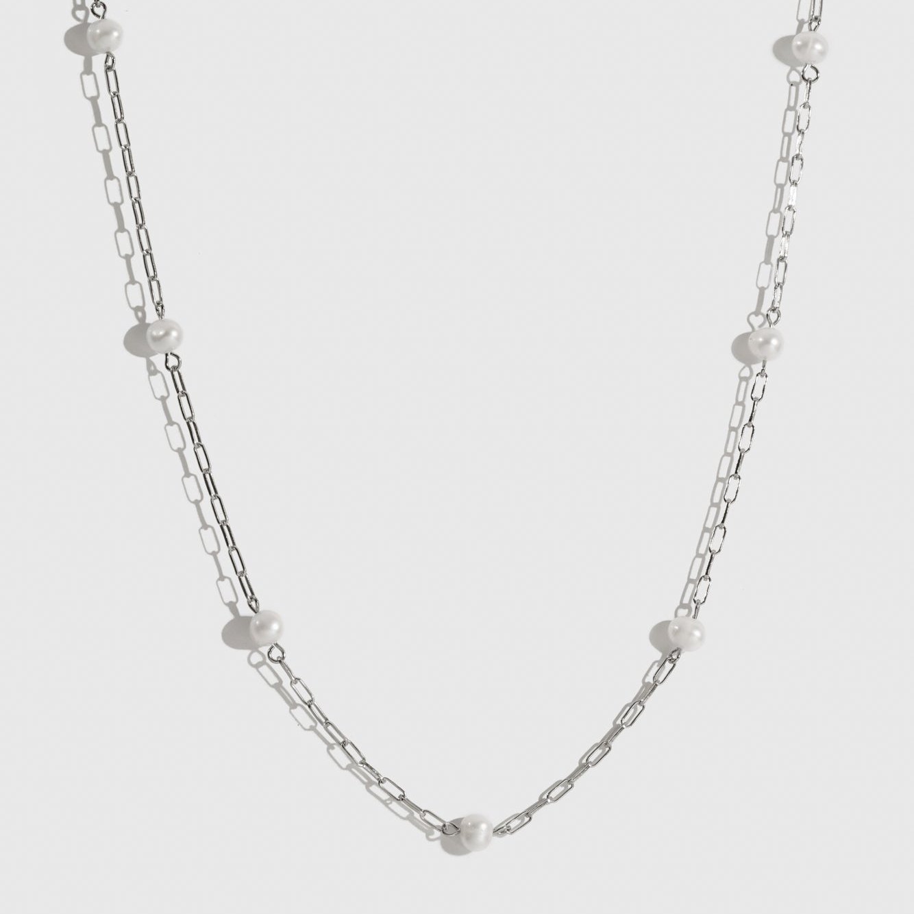 Sterling silver 925 multi paperclips and pearls necklace with freshwater pearls, shown on a plain background.