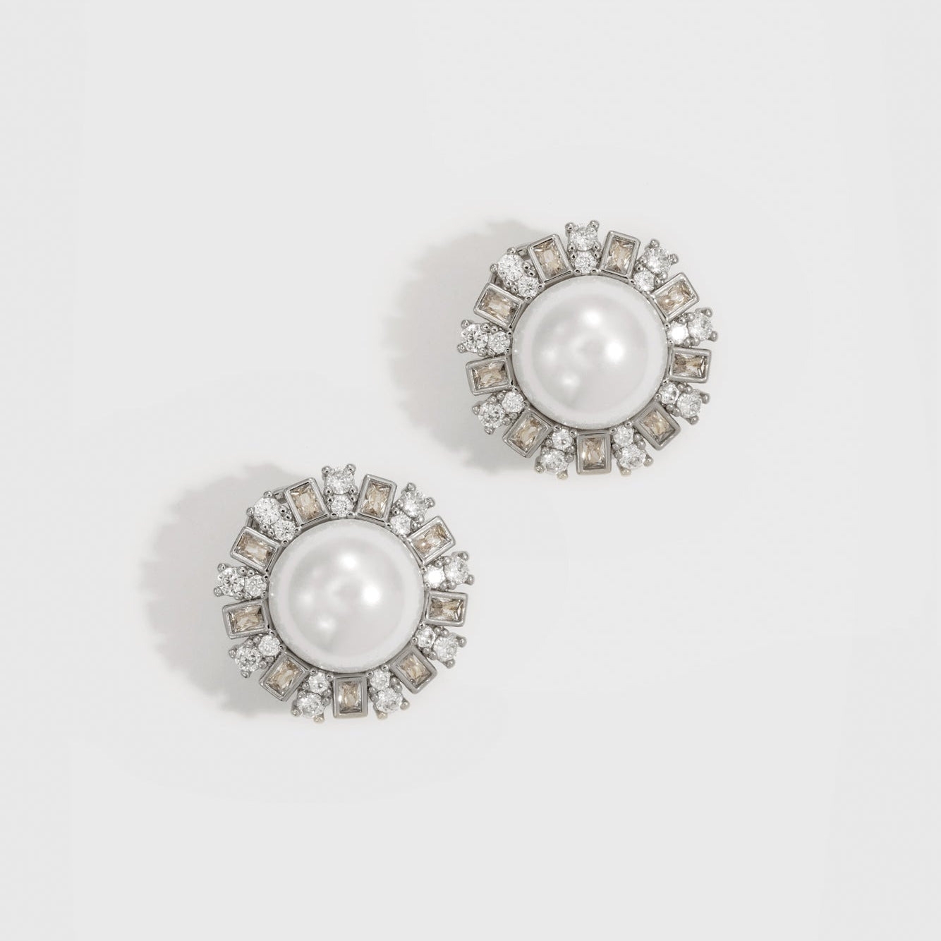 Silver plated vintage stud earrings with a glass pearl and white cubic zirconia, shown on a plain background.