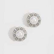 Silver plated vintage stud earrings with a glass pearl and white cubic zirconia, shown on a plain background.