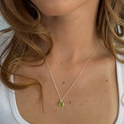 Necklace with a green pendant worn by a person