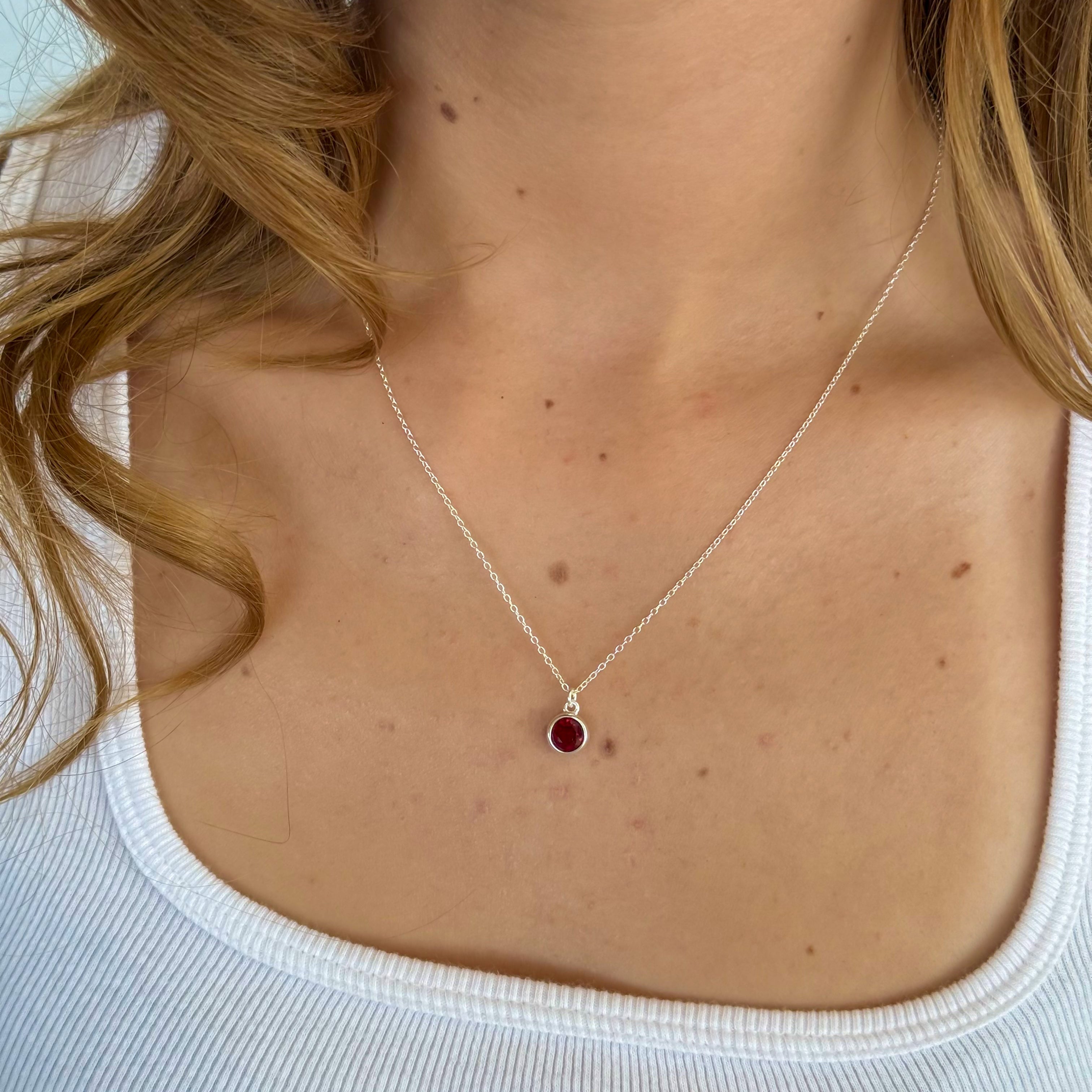 Necklace with a red pendant worn by a person